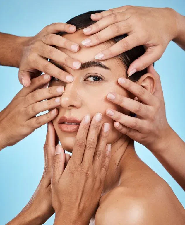 Woman's face surrounded by multiple hands.